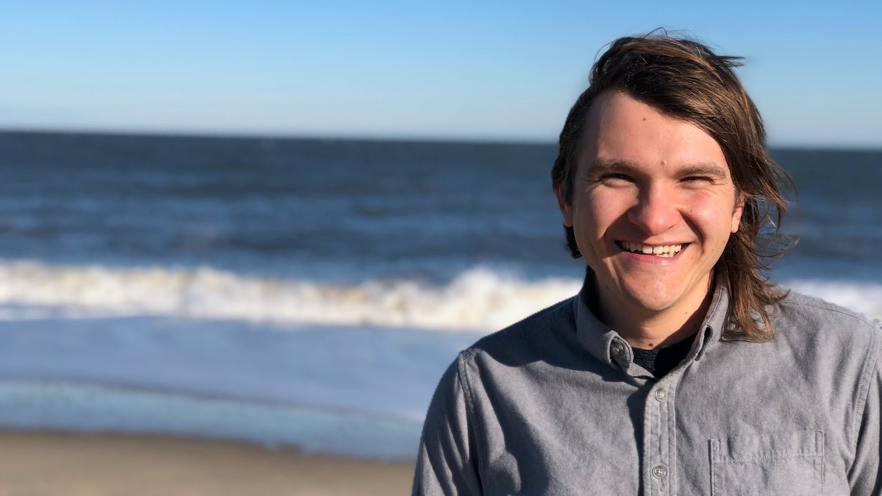 Photo of Brett smiling at the beach